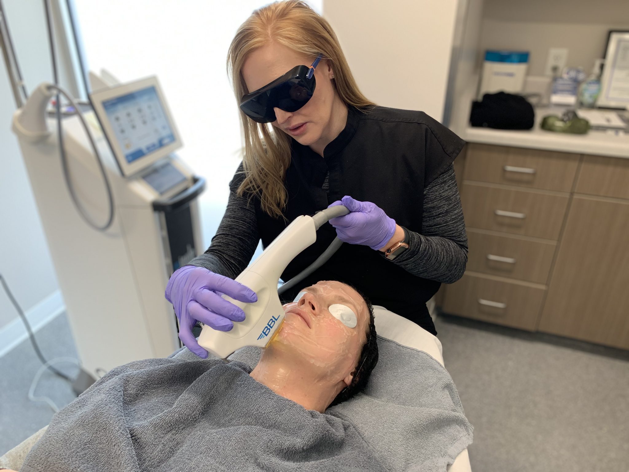 A Lazaderm provider holds the BBL laser to a patients skin.