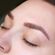 Close-up of a person's face with eyes closed, focusing on freshly microbladed eyebrows. The skin around the eyebrows appears smooth and slightly red, indicating recent treatment. The eyebrows are well-defined with fine, hair-like strokes.