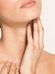 A woman with fair skin touching her neck gently, looking upwards, isolated on a light background, emphasizing skincare or health.