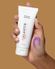 hand holding a tube of Alastin skincare product