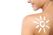 A profile view of a woman with a sun design drawn in sunscreen on her back, smiling, against a white background.